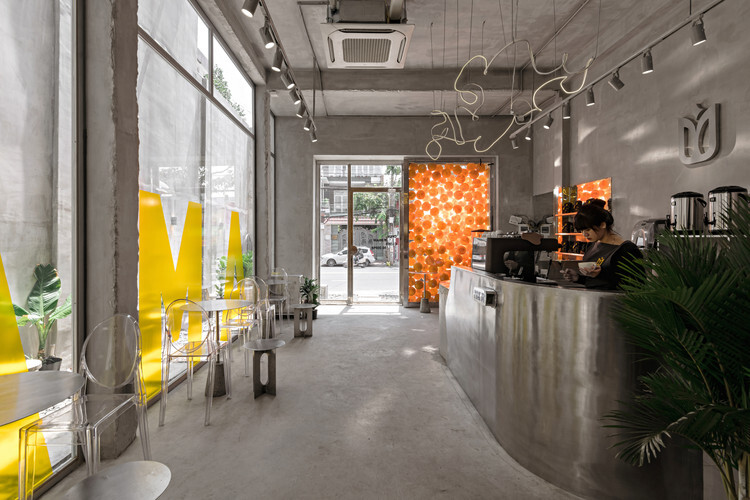 Hình ảnh mẫu quán cafe màu xám xi măng kết hợp vàng khi nhìn từ bên trong ra ngoài