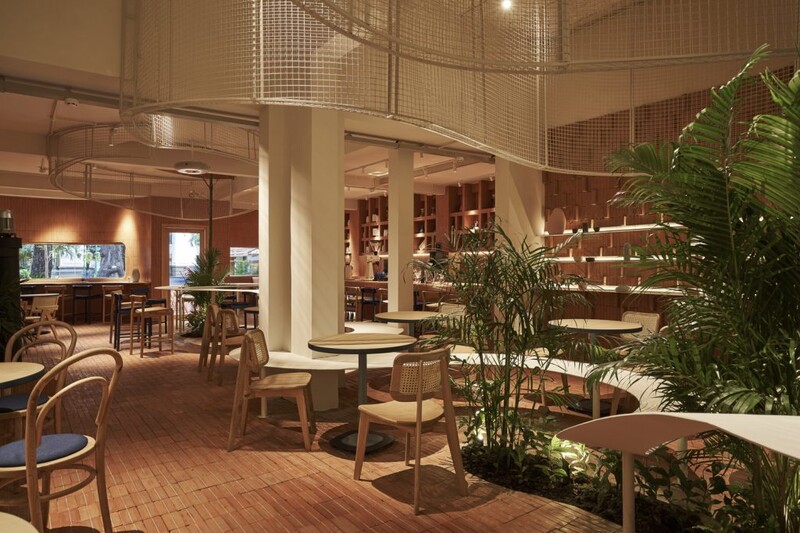 Sử dụng cây xanh trang trí khiến cho quán cafe tông màu đỏ gạch trở nên trong lành và mát mẻ hơn